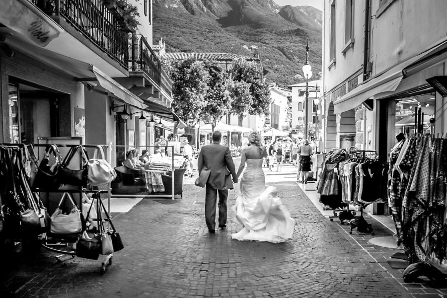 destination wedding lake garda malcesine castle italy bride groom walking street town